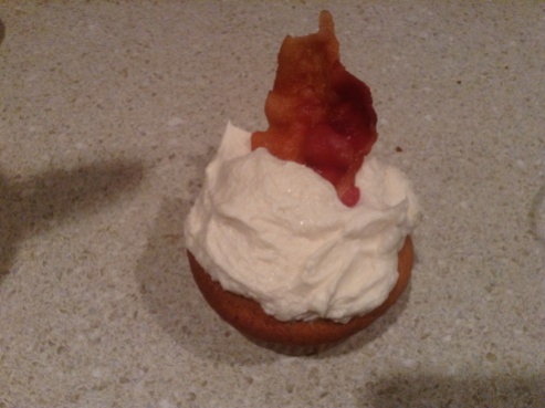 French Toast Cupcake with Maple Buttercream Frosting Garnished with a Piece of Maple Bacon